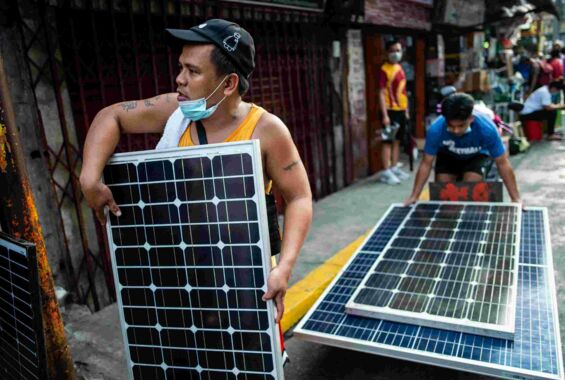 Zwei Handwerker auf den Philippinen transportieren Solarpaneele