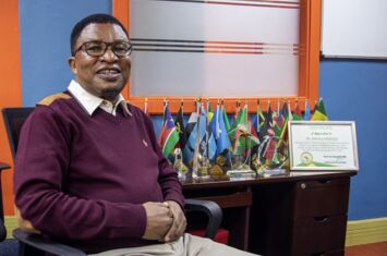 Portrait von Mithika Mwenda (Direktor der Panafrican Climate Justice Alliance) in seinem Büro mit Zertifikat für die 100 wichtigsten Persönlichkeitenn