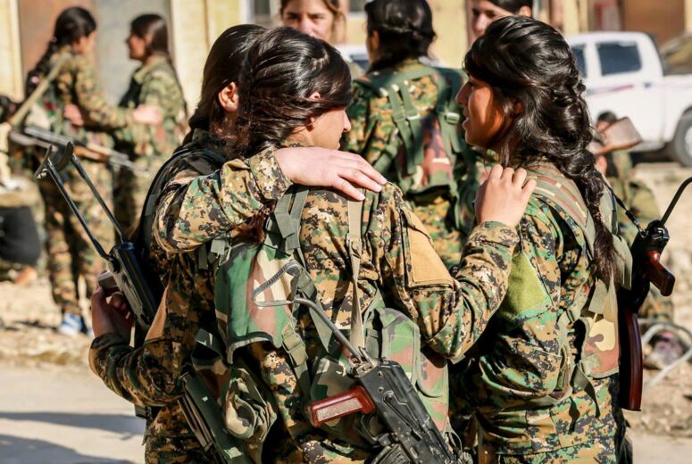 Drei Kämpferinnen der YPJ (Yekîneyên Parastina Jin) stehen zusammen und halten sich im Arm