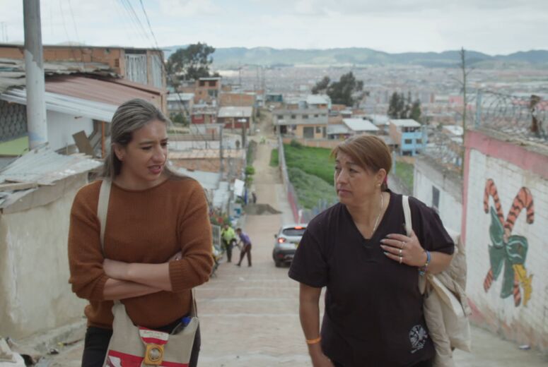 Zwei Frauen, Protagonistinnen des Films »Hijos del viento« laufen eine Treppe hoch. Im Hintergrund ist die Stadt zu sehen.