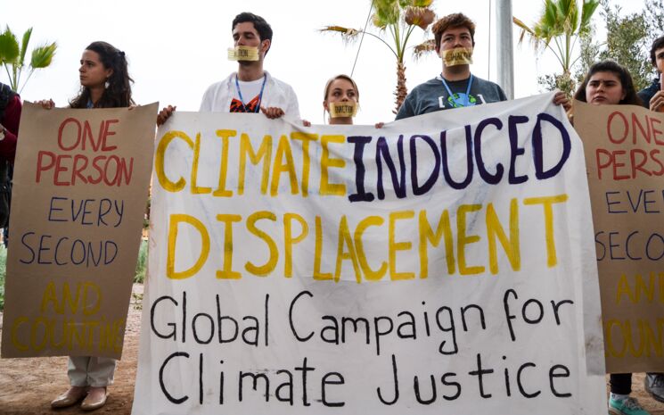 Mehrere Aktivist*Innen demonstrieren friedlich für eine globale Lösung der Klimakrise induzierten Migration