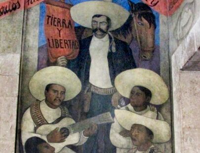Musiker spielen Gitarre. Im Hintergrund Emiliano Zapata