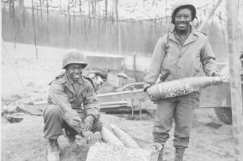 William E. Thomas und Joseph Jackson vom 969th Field Artillery Battalion der US-Armee posieren am 10. März 1945 mit beschrifteten Geschossen