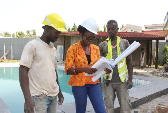 eine Architektin udn zwei Bauarbeiter bei der Arbeit in Lomé
