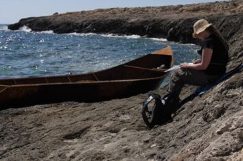 Mittelmeer: Archäologin Geesche Wilts sitzt auf einer Klippe und dokumentiert ein Metallboot. Das Boot hatten Geflüchtete genutzt.