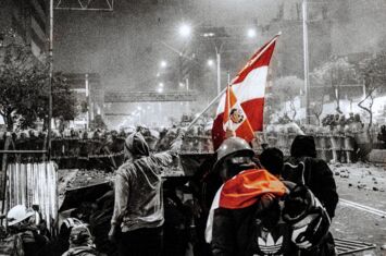 Schwarzweiß-Foto: Protestierende stehen mit roten Flaggen einer Polizeikette gegenüber.