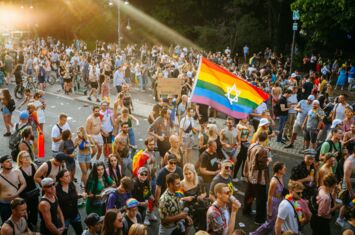 Queer und jüdisch: Foto des CSD in Berlin. Aus der Menschenmenge ragt eine Pride-Fahne mit Davidstern heraus.