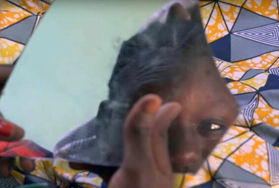 Frau schaut sich selber in einer Spiegelschrebe an - Still aus dem Dokumentarfilm