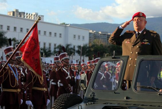 Präsident Hugo Chávez bei einer Militärparade, in Uniform auf einem Militärwagen, vorbeifahrend an Soldaten