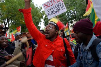 Szene eines Straßenprotests gegen Faure Gnassingbé in Belgien. Die Menschen schwingen togoische Fahnen und Schilder