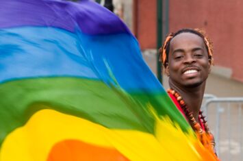 Regenbogenflagge in Bewegung mit einer Person während der Gay Pride in New York
