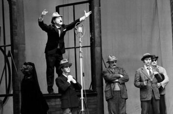 5 Männer auf einer Theaterbühne - einer spricht in eine Mikrofon - aus: »Der aufhaltsame Aufstieg des Arturo Ui«