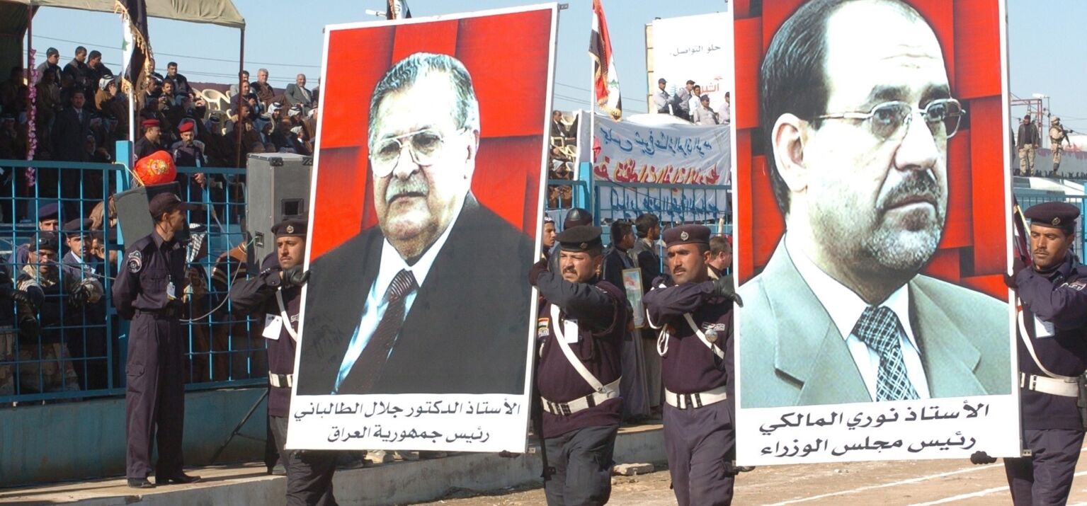 Auf einem Demonstrationszug zeigt die irakische Polizei Poster von den kurdischen Politikern Talabani und al-Maliki