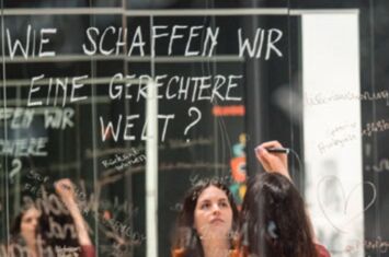 An einer Tafel wird geschrieben: Wie schaffen wir eine gerechte Welt? Workshop Kolonialgeschichte