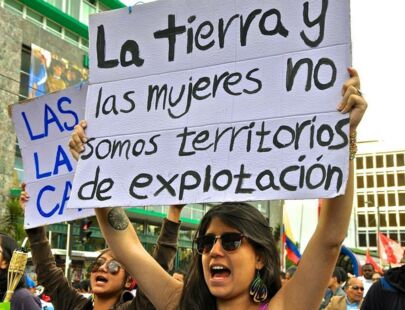 Demonstrant*innen in Ecuador halten Schilder in die Luft und rufen